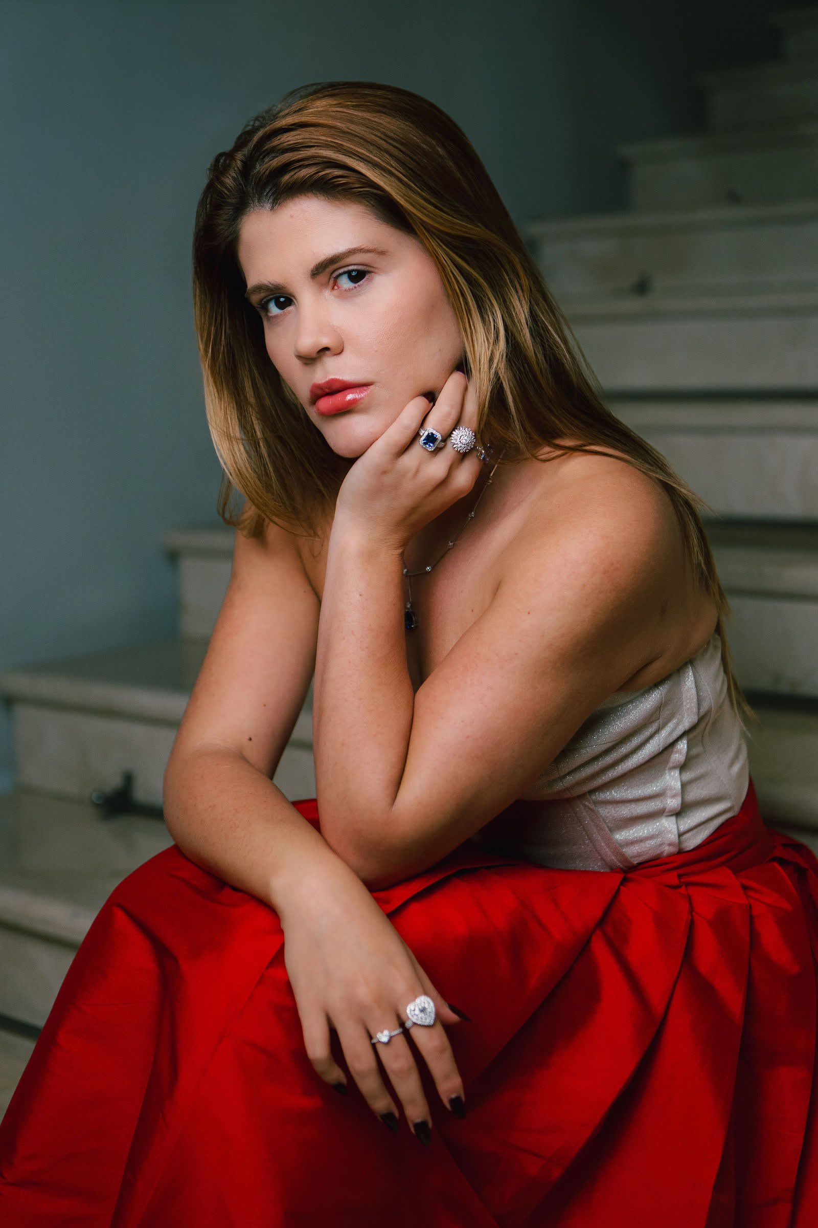 Model in a bustier and red skirt, wearing the Sovereign Ring and the Sunburst Ring