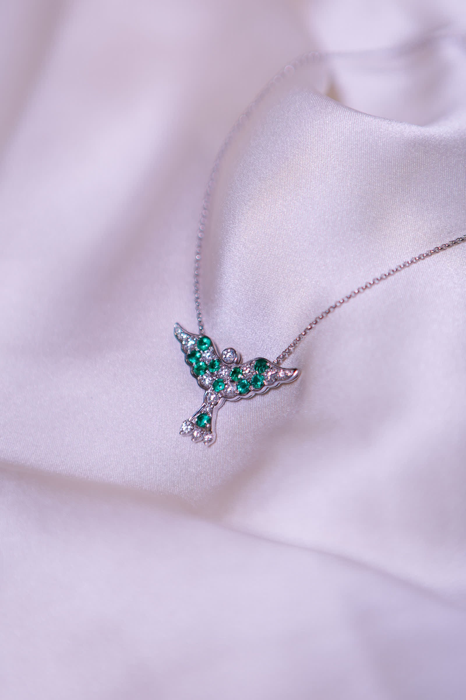 Leaf Necklace — An emerald leaf motif set off the center line.